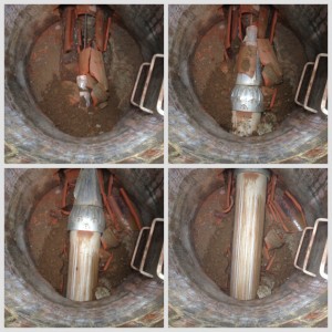 Reversible Hercules Grundocrack pneumatic hammer with guide head passing through an intermediate manhole while pipe bursting 10-inch VCP and pulling in 12-inch HDPE.